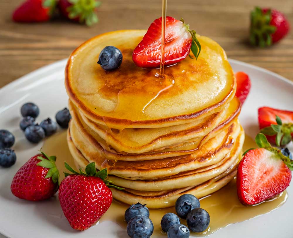 pancakes Delicious stack of pancakes with syrup and fresh fruit